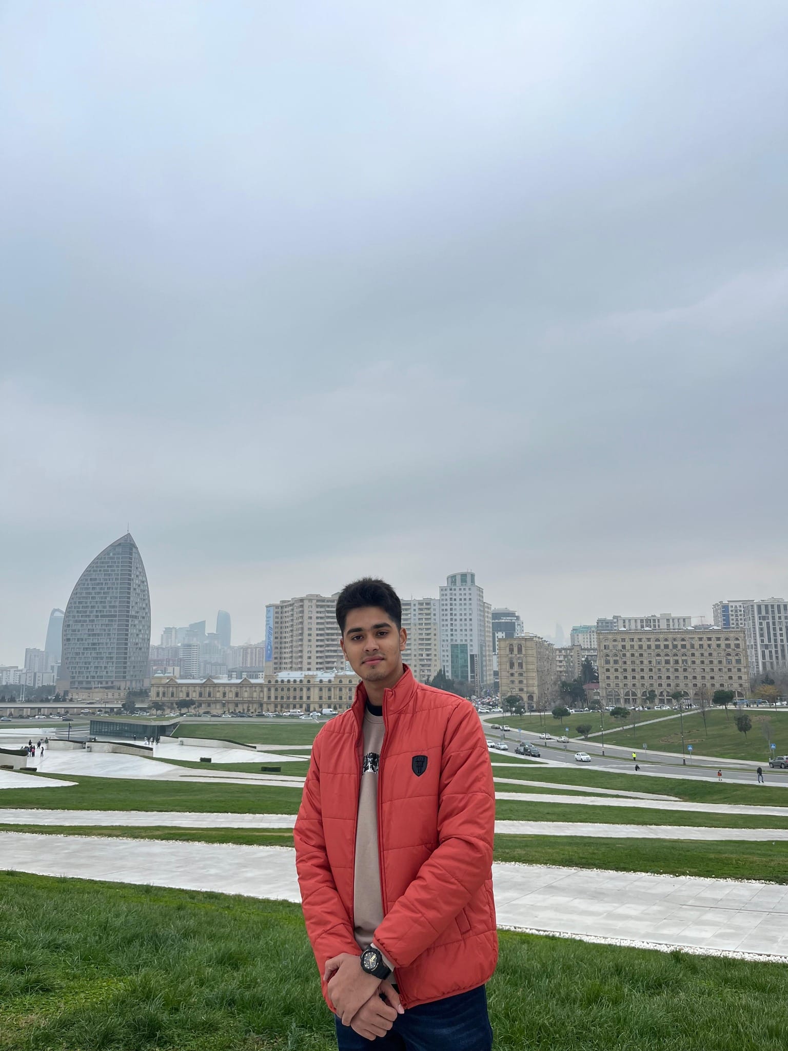 Shubham outdoors in Baku, with the city skyline behind him